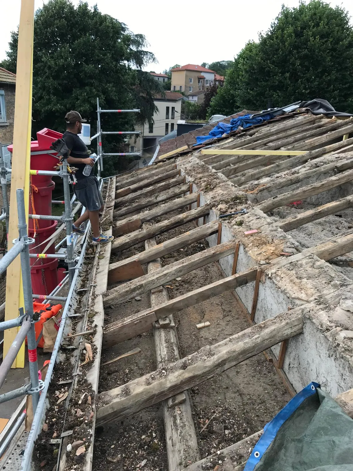 Chantier de rénovation de toiture avec dépose du liteaunage et charpente mise à nu sur échafaudage, par Muller Toiture, couvreur Nord-Isère