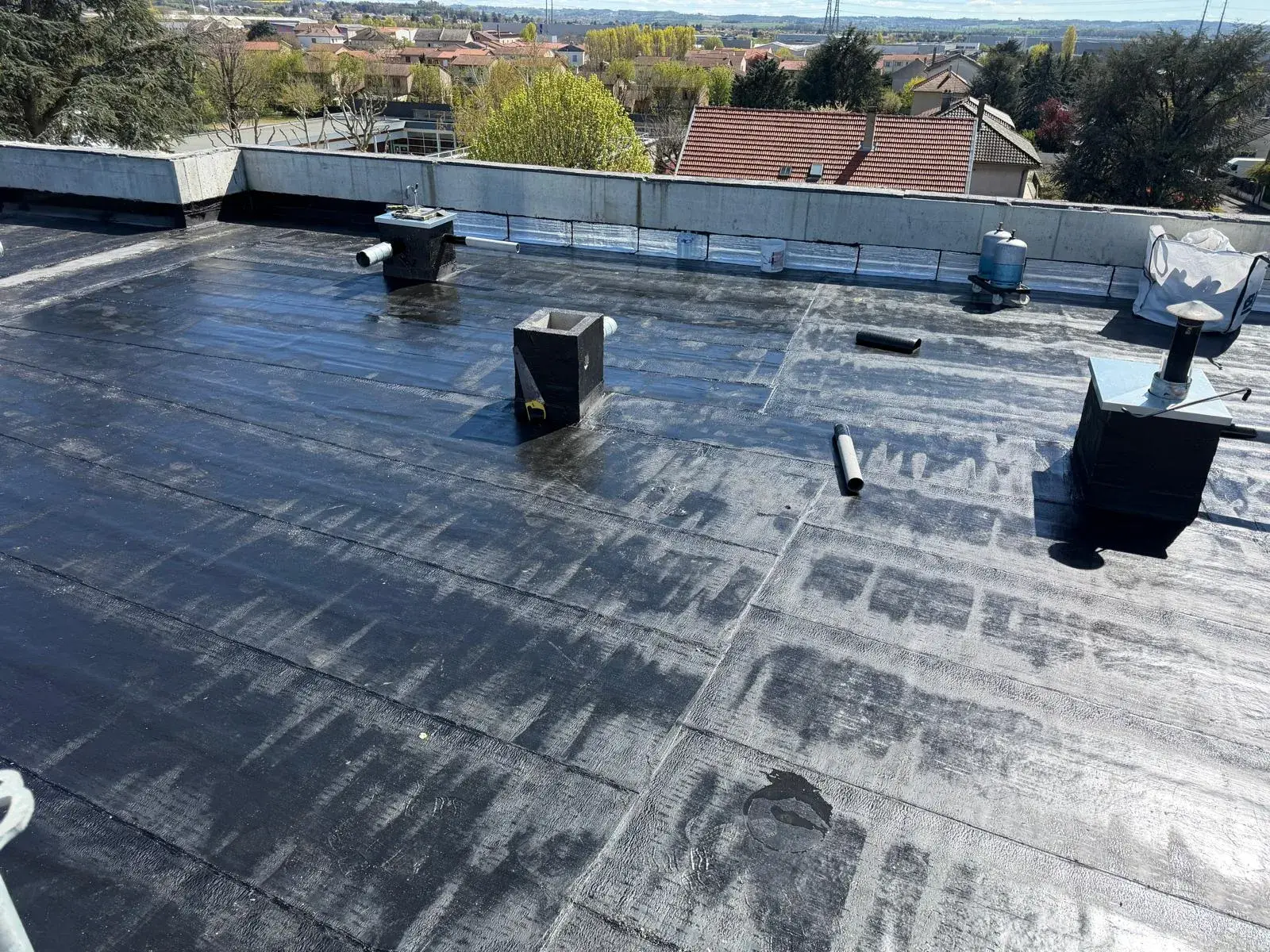 Toiture-terrasse recouverte d'une membrane d'étanchéité bitumineuse avec sorties de ventilation, par Muller Toiture, couvreur dans l'Est lyonnais