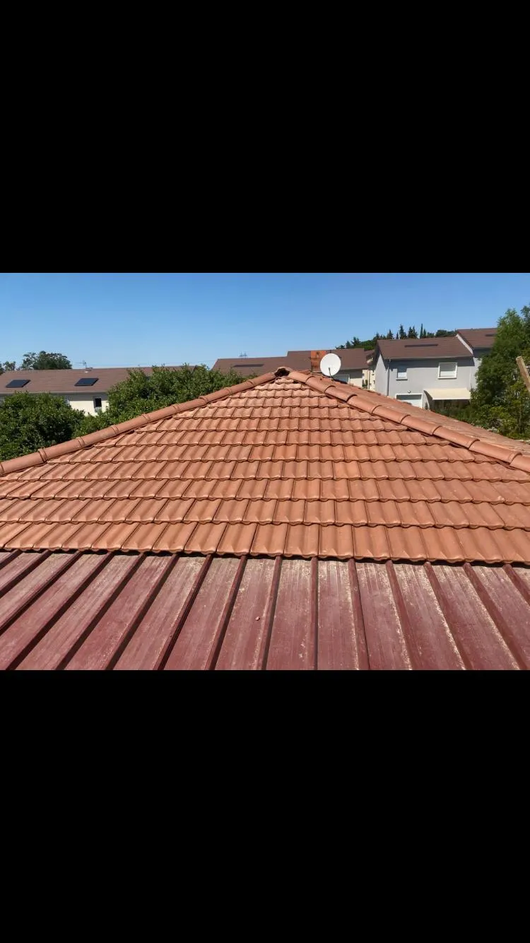 Toiture en tuiles terre cuite à plusieurs pans avec faîtage et arêtiers refaits par Muller Toiture, couvreur à Mions