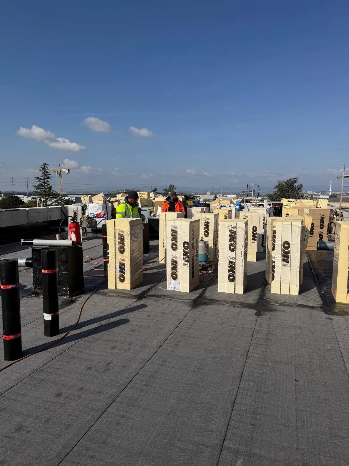 Panneaux isolants rigides répartis sur une toiture-terrasse en cours d'isolation par Muller Toiture, couvreur dans l'Est lyonnais