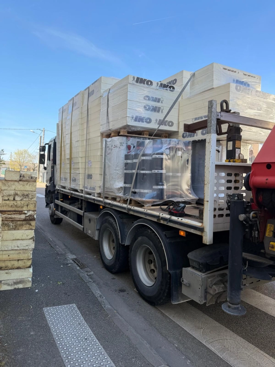 Livraison par camion grue de matériaux de couverture sur un chantier Muller Toiture