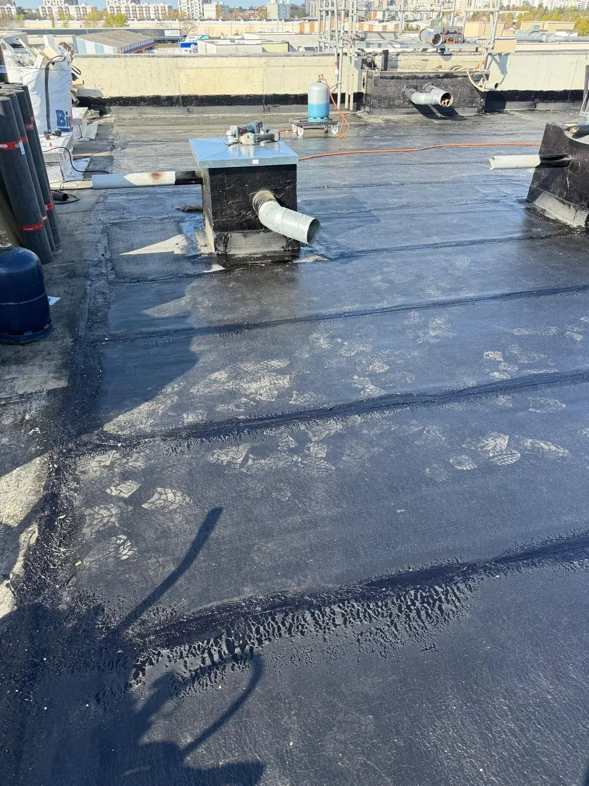 Membrane d'étanchéité bitumineuse soudée autour d'une souche de ventilation sur toiture-terrasse par Muller Toiture, couvreur dans l'Est lyonnais
