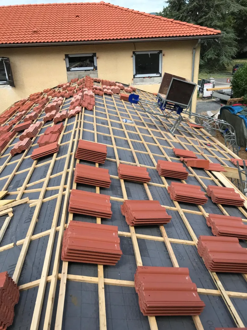 Rénovation de toiture en cours avec tuiles neuves par Muller Toiture
